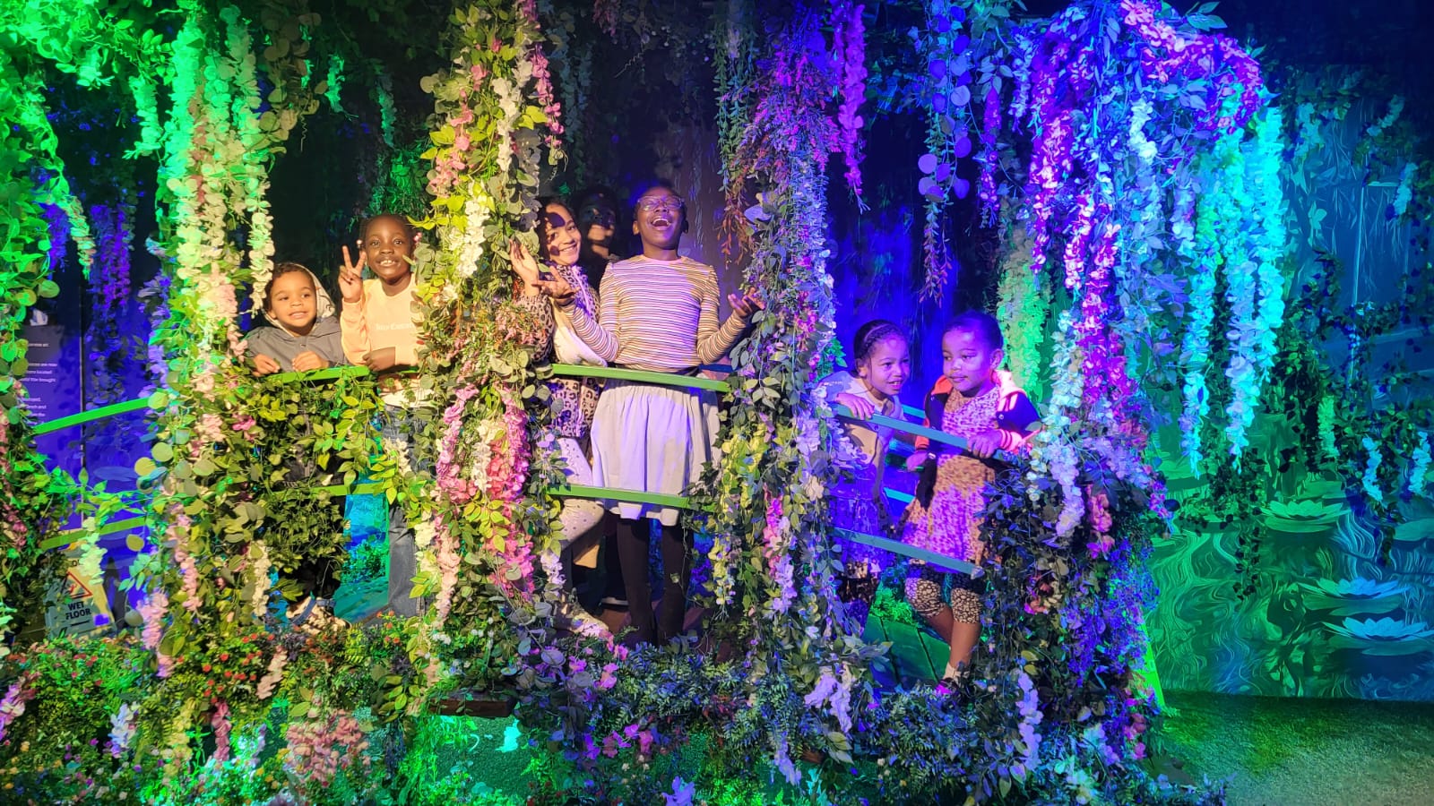 Group of youth performers on stage, singing and acting with foliage in the background, displaying their creativity and talent.